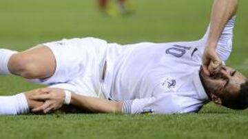 Benzema se duele en el suelo tras el choque con Casillas y Busquets.