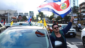Un hombre ondea la bandera de Costa Rica antes de las elecciones del domingo, con las encuestas indicando a Laura Fernández, del Partido Popular Soberano (PPSO), como clara favorita, en medio de un aumento del tráfico de drogas y la violencia que ha erosionado la imagen del país como un paraíso turístico pacífico, en San José, Costa Rica, el 31 de enero de 2026.