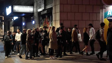 People walk in a street outside nightclubs in Barcelona on February 10, 2021. - In the northeastern region of Catalonia, nightlife venues were set to open at the stroke of midnight (2300 GMT) on February 11, 2022. In late December, the Catalan government put in place some of Spain's most restrictive measures to fight Omicron, imposing a night curfew from 1:00 am, closing nightlife venues and halving the capacity in bars and restaurants. (Photo by Pau BARRENA / AFP)