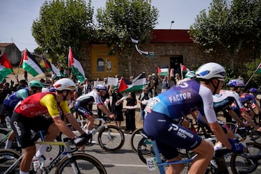 El grupo avanza mientras manifestantes pro-palestinos sostienen banderas palestinas durante la 20ª etapa de la Vuelta a España 2025.