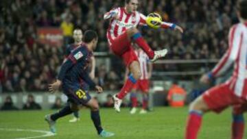 Koke controla un balón ante la mirada de Adriano.