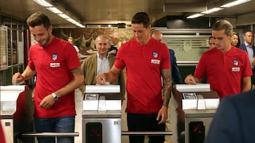 Saúl, Torres y Griezmann pasando los tornos del Metro.