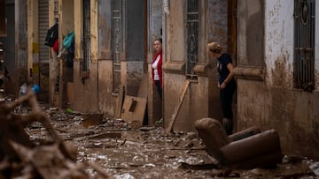 Unas mujeres se encuentran a la entrada de sus casas afectadas por las inundaciones en Masanasa, Valencia.