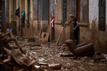 Unas mujeres se encuentran a la entrada de sus casas afectadas por las inundaciones en Masanasa, Valencia.