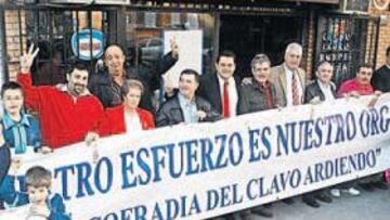 <b>'PANCARTÓN'. </b>Una veintena de adultos y niños posan junto a la pancarta de la Cofradía del Clavo Ardiendo bajo el lema: "Vuestro esfuerzo es nuestro orgullo".