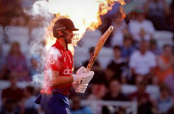 Will Jacks, jugador de críquet inglés, sale al terreno de juego mientras el fuego sobresale a su espalda. 