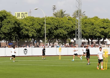 Primer entrenamiento en césped del Valencia con el cartel 'Lim Go Out' de fondo.