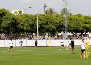 Primer entrenamiento en c谷sped del Valencia con el cartel 'Lim Go Out' de fondo.