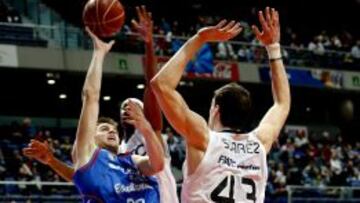 El alero del Estudiantes Xavi Rabaseda (i) lanza a canasta ante el alero del Joventut Álex Suárez (d).