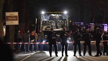 Police officers stand in front of Dortmund's damaged team bus after an explosion before the Champions League quarterfinal soccer match between Borussia Dortmund and AS Monaco in Dortmund, western Germany, Tuesday, April 11, 2017. (AP Photo/Martin Meissner)