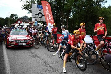 Ciclistas del pelot¨®n espectantes tras la detenci¨®n de la carrera debido al accidente masivo en el que cayeron al suelo m¨¢s de 30 ciclistas.