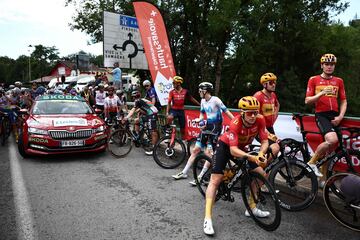 Ciclistas del pelotón espectantes tras la detención de la carrera debido al accidente masivo en el que cayeron al suelo más de 30 ciclistas.