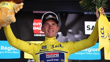 Soudal Quick-Step's Belgian rider Remco Evenepoel celebrates wearing the overall leader's yellow jersey after winning the stage on the podium of the 4th stage of the 77th edition of the Criterium du Dauphine cycling race, a 17,4 km individual time trial between Charmes-sur-Rh�ne and Saint-P�ray, on June 11, 2025. (Photo by Anne-Christine POUJOULAT / AFP)