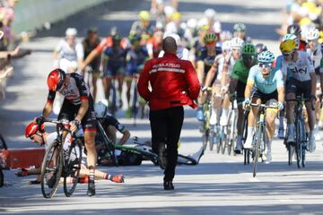 Un miembro de la organización corre a atender a los heridos después de una caída múltiple durante el esprint final.