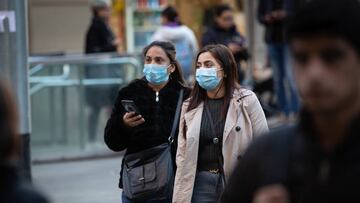 Dos mujeres con mascarillas caminan por Barcelona.