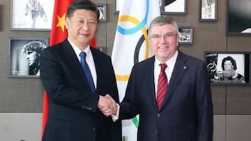 El presidente chino Xi Jinping saluda al presidente del COI Thomas Bach en una reunión en Lausana.
