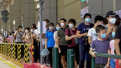 FILE PHOTO: Residents wearing face masks line up to get tested for the coronavirus disease (COVID-19) in Macau, China July 4, 2022. REUTERS/John Mak/File Photo
