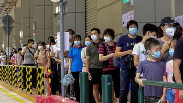 FILE PHOTO: Residents wearing face masks line up to get tested for the coronavirus disease (COVID-19) in Macau, China July 4, 2022. REUTERS/John Mak/File Photo