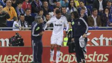 Varane, ayudado por el doctor Paco Morate y el fisio Daniel Martínez.