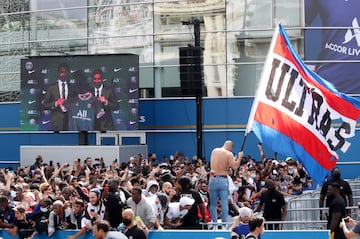 Los aficionados del PSG siguen en pantallas gigantes la presentación de Leo Messi en el exterior del estadio.