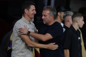 El segundo entrenador del Getafe (izquierda), Patricio Moreno, saluda al técnico del Barcelona (derecha), Hansi Flick.