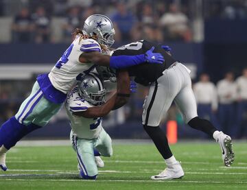 Jaylon Smith (54) y Byron Jones (31), de los Dallas Cowboys, tacklean a Jared Cook (87), de los Oakland Raiders.