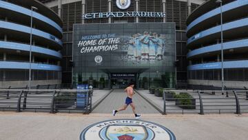 Soccer Football - Premier League - Today would have been the final fixtures of the season - Etihad Stadium, Manchester, Britain - May 17, 2020 A man is seen running outside the stadium at the time the final match of season between Manchester City and No