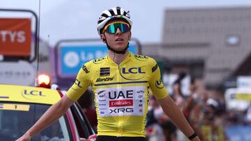 UAE Team Emirates XRG's Slovenian rider Tadej Poga?ar wearing the overall leader's yellow jersey celebrates as he crosses the finish line to win the 7th stage of the 77th edition of the Criterium du Dauphine cycling race, 131,6 km between Grand-Aigueblanche and Valmeinier, on June 14, 2025. (Photo by Anne-Christine POUJOULAT / AFP)