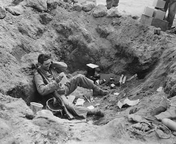 El correo trae sonrisas a un soldado de la  marina en una trinchera de primera línea en la Batalla de Iwo Jima. Esta batalla fue una de las más sangrientas de la guerra entre los infantes de marina de los Estados Unidos y las fuerzas del ejército del Imperio del Japón.