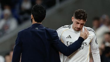 Real Madrid's Uruguayan midfielder #08 Federico Valverde embraces Real Madrid's Spanish coach Alvaro Arbeloa as he leaves the pitch after being substituted during the Spanish league football match between Real Madrid CF and Elche CF at the Santiago Bernabeu Stadium in Madrid on March 14, 2026. (Photo by Oscar DEL POZO / AFP)