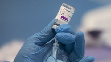 Una profesional sanitaria sostiene una jeringuilla con un vial de la vacuna contra la COVID-19 de AstraZeneca