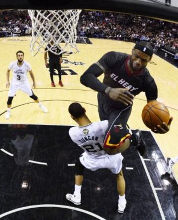 El jugador de los Heat de Miami LeBron James (d) cae sobre Tim Duncan, de los Spurs de San Antonio, durante el partido de la NBA disputado en el AT&T Center en San Antonio, Texas (EE.UU.).