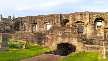 Stirling, Scotland, United Kingdom - April 28, 2022: View of medieval wall ruins along the cemetery grounds of the Church of the Holy Rude. Gravestones date to the 16th century.