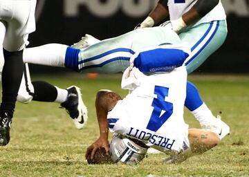 El quaterback de los Dallas Cowboys, Dak Prescott hace una voltereta en una jugada contra los Oakland Raiders.