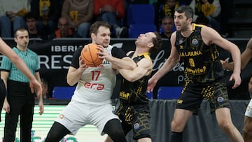 El alero del Era Nymburk, Jaromir Bohacik (i), lucha con el base del La Laguna Tenerife, Marcelinho Huertas (c), durante el partido correspondiente a la segunda ronda de la Liga de Campeones de Baloncesto entre La Laguna Tenerife y el Era Nymburk de la República Checa, este martes en el Pabellón Santiago Martín de La Laguna (Tenerife).
