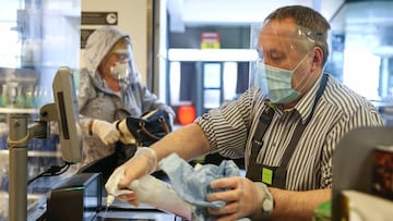 LONDON, ENGLAND - APRIL 13: A Waitrose employee cleans a check out while wearing personal protective equipment on April 13, 2020 in South West London, United Kingdom. The Coronavirus (COVID-19) pandemic has spread to many countries across the world, claim