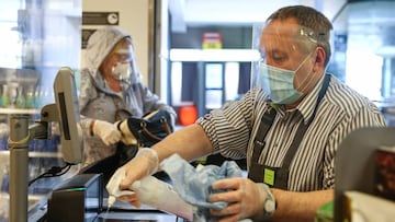 LONDON, ENGLAND - APRIL 13: A Waitrose employee cleans a check out while wearing personal protective equipment on April 13, 2020 in South West London, United Kingdom. The Coronavirus (COVID-19) pandemic has spread to many countries across the world, claim