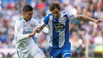 El centrocampista brasileño del Real Madrid, CArlos Henrique Casimiro y el centrocampista del Deportivo Pedro Mosquera luchan por el balón durante el partido de la vigésima jornada de Liga que disputan en el estadio Santiago Bernab&ea