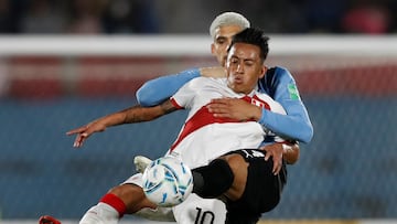 Peru's Christian Cueva (Front) and Uruguay's Ronald Araujo (Back) vie for the ball during their South American qualification football match for the FIFA World Cup Qatar 2022 at the Centenario Stadium in Montevideo on March 24, 2022. (Photo by Matilde Campodonico / POOL / AFP)