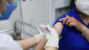 FILE PHOTO: A woman receives a vaccine as Vietnam starts its official rollout of AstraZeneca's coronavirus disease (COVID-19) vaccine for health workers, at Hai Duong Hospital for Tropical Diseases, Hai Duong province, Vietnam, March 8, 2021. REUTERS/Thanh Hue/File Photo