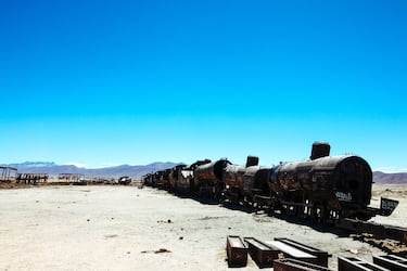 Uyuni es conocida sobre todo por sus salinas y lagunas rojas, pero Bolivia cuenta con otra inusual atracción turística: un "cementerio" de trenes antiguos abandonados. A principios del siglo XIX, se planificó la ampliación de la red de transporte de Uyuni y la construcción de más vías de tren a través de la ciudad, pero el proyecto se abandonó por dificultades técnicas y tensiones con los indígenas locales.

Los trenes siguieron utilizándose para transportar minerales a las ciudades portuarias del Pacífico, pero los minerales se agotaron en la década de 1940, los mineros abandonaron la ciudad y el equipo quedó abandonado en el desierto. El tiempo y los vientos salinos han corroído los trenes desde entonces, dando lugar al Gran Cementerio de Trenes que se ve hoy en día.