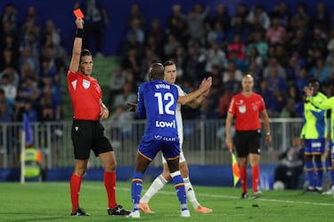 Spanish referee Jose Luis Munuera Montero shows a red card to Getafe's Cameroonian midfielder #12 Allan-Romeo Nyom during the Spanish league football match between Getafe CF and Real Madrid CF at Coliseum Alfonso Perez Stadium in Getafe on October 19, 2025. (Photo by Thomas COEX / AFP)