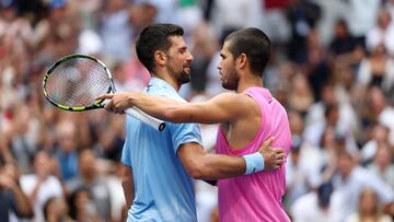 Carlos Alcaraz y Novak Djokovic (I) se saludan al final de su partido en el US Open.