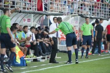 El árbitro Fernández Borbalán pide calma a los jugadores del Athletic sentados en el banquillo.