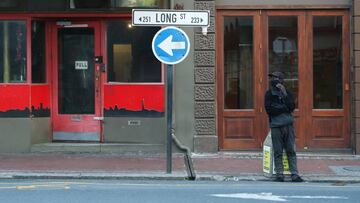 An informal car-guard stands before a closed bar and restaurant in Long Street, normally bustling with foreign tourists, as coronavirus disease (COVID-19) lockdown regulations ease in Cape Town, South Africa, August 24, 2020. Picture taken August 24, 2020