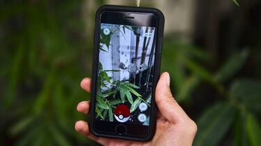 A man plays Pokemon Go on his mobile phone in Mexico City, on August 10, 2016. / AFP PHOTO / RONALDO SCHEMIDT