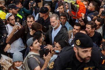 El Rey Felipe VI y el presidente de la Generalitat valenciana, Carlos Mazón, durante su visita a una zona afectada por la DANA, a 3 de noviembre de 2024, en Paiporta, Valencia.