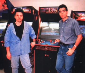 Ed Boon y John Tobias posan con una recreativa de Mortal Kombat 3.