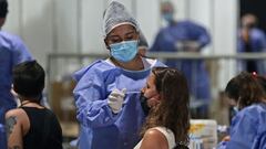 A health worker swabs a woman for the novel coronavirus disease COVID-19 at a free testing center in Buenos Aires, on January 10, 2022. (Photo by ALEJANDRO PAGNI / AFP)