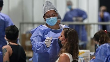 A health worker swabs a woman for the novel coronavirus disease COVID-19 at a free testing center in Buenos Aires, on January 10, 2022. (Photo by ALEJANDRO PAGNI / AFP)